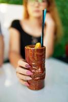 Woman at table in cafe with cocktail. photo