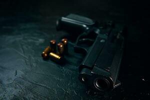 Black gun and bullets on table. photo