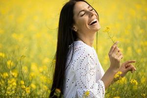 mujer joven en el campo de colza foto