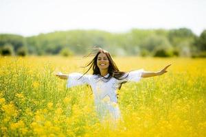 mujer joven en el campo de colza foto