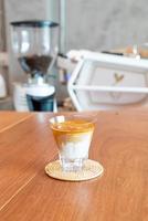 Dirty coffee glass, or cold milk topped with hot espresso coffee shot, in a coffee shop photo