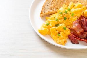 Scrambled egg with bread toasted and bacon for breakfast photo