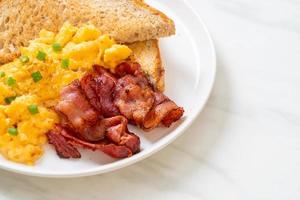 Scrambled egg with bread toasted and bacon for breakfast photo