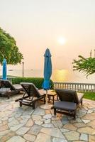 Beach chairs or pool beds with umbrellas around swimming pool at sunset time photo