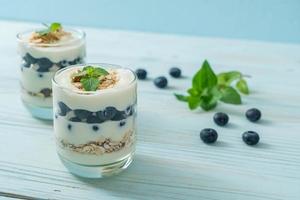 arándanos frescos y yogur con granola - estilo de comida saludable foto