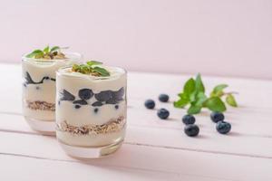 arándanos frescos y yogur con granola - estilo de comida saludable foto