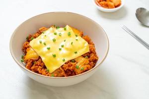 arroz frito con kimchi con cerdo y queso cubierto - estilo de comida asiática y fusión foto