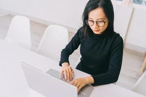 Young Asian woman using laptop in the office photo
