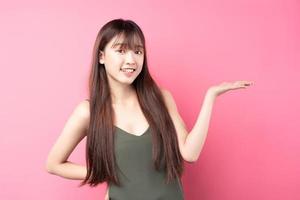 joven asiática posando sobre un fondo rosa foto