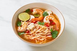 Instant noodles ramen in spicy soup with shrimps, or Tom Yum Kung - Asian food style photo