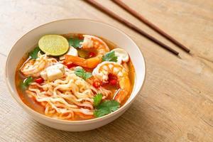 Instant noodles ramen in spicy soup with shrimps, or Tom Yum Kung - Asian food style photo