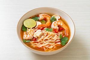 Instant noodles ramen in spicy soup with shrimps, or Tom Yum Kung - Asian food style photo