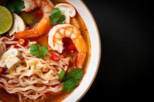 Instant noodles ramen in spicy soup with shrimps, or Tom Yum Kung - Asian food style photo