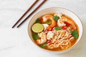 Instant noodles ramen in spicy soup with shrimps, or Tom Yum Kung - Asian food style photo