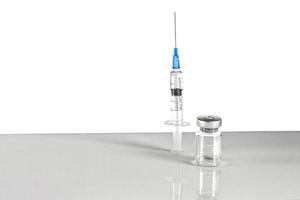 Syringe and vial with coronavirus vaccine, injection vial dose on a gray background. Prevention, medical concept, covid-19 immunization. photo