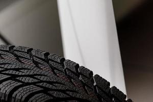 Stack of brand new high performance car tires on clean high-key white studio background. new car tire background. close up of texture photo