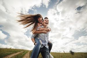 Pareja joven loca divirtiéndose emocionalmente, besándose y abrazándose al aire libre. amor y ternura, romance, familia, emociones, diversión. divirtiéndonos juntos foto