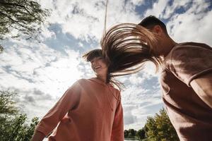 Pareja joven loca divirtiéndose emocionalmente, besándose y abrazándose al aire libre. amor y ternura, romance, familia, emociones, diversión. divirtiéndonos juntos foto