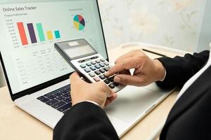 Asian accountant working and analyzing financial reports project accounting with chart graph and calculator in modern office, finance and business concept. photo