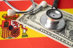 Black stethoscope on Spain and US dollar banknotes flag background, Business and finance concept. photo