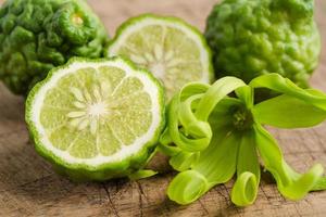 Fresh bergamot fruit with cut in half on wooden background. photo