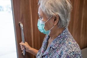 Asian senior or elderly old lady woman patient wearing face mask use toilet bathroom handle security in nursing hospital ward, healthy strong medical concept.