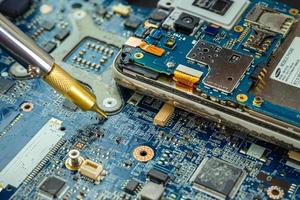 Technician repairing inside of hard disk by soldering iron. Integrated Circuit. The concept of data, hardware, technician and technology. photo