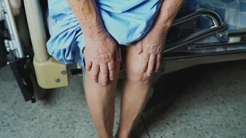Aziatische senior of oudere oude dame vrouw patiënt toont haar littekens chirurgische totale kniegewricht vervanging hechtdraad wond chirurgie artroplastiek op bed in verpleegafdeling ziekenhuis, gezond sterk medisch concept.