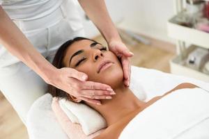 mujer recibiendo masaje de cabeza en el centro de bienestar spa. foto