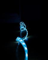 blue glowing LED strip with cold light on a black background close-up, decorative lighting photo