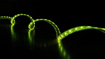 luminous LED decorative strip of green color on a black background photo