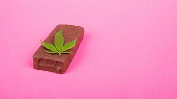 cannabis sweet food candy on pink background with copy space photo