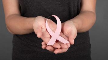 pink ribbon in the palms, breast cancer fight symbol, oncology photo