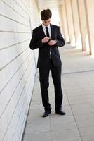 Attractive young business man in urban background photo