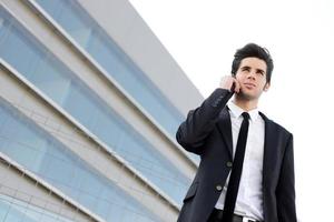 Attractive young businessman on the phone in an office building photo