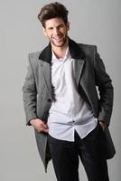 Handsome young man wearing coat. Studio shot photo