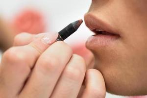 Makeup artist making up lips of an African young woman photo