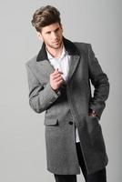 Handsome young man wearing coat. Studio shot photo