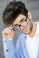 Cheerful trendy guy with black eyeglasses on photo