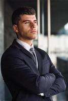 Young businessman near an office building wearing black suit photo