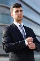 Young businessman near an office building wearing black suit photo