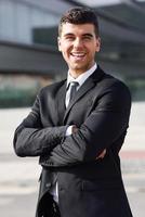 Young businessman near an office building wearing black suit photo