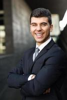 Young businessman near an office building wearing black suit photo