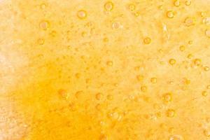 golden background of marijuana wax close-up, cannabis dab texture photo