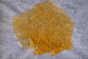 amber cannabis wax with high THC content, marijuana dab concentrate photo