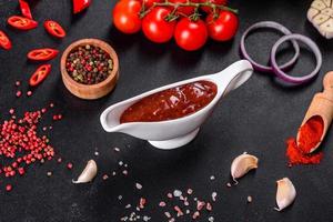 condimento picante de la cocina georgiana adjika en un recipiente con pimiento rojo y ajo foto