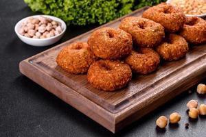 Hermoso delicioso falafel de garbanzos frescos con salsas sobre un fondo de hormigón foto