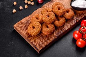 Beautiful delicious fresh chickpea falafel with sauces on a concrete background photo