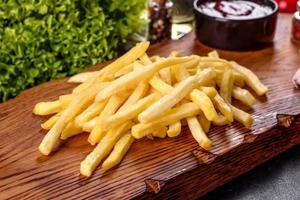 Fresh hot french fries with salt vegetables and spices photo