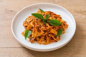 Farfalle pasta with basil and garlic in tomato sauce - Italian sauce photo